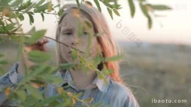 一个小女孩带着悲伤的表情透过一棵枝叶繁茂的树的特写